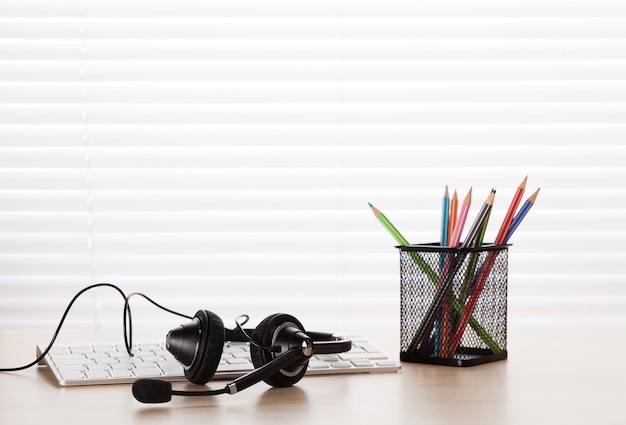 Escritorio de oficina con auriculares y pc.