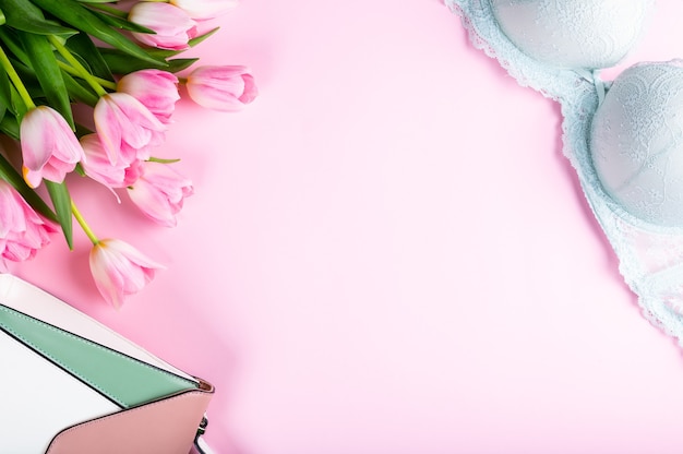 Escritorio de oficina en casa femenino. Espacio de trabajo con cuaderno, flores de tulipán rosa y accesorios. Vista plana endecha, superior. Fondo de blog de moda. Mujeres rotundamente. Flatlay del día de la mujer.