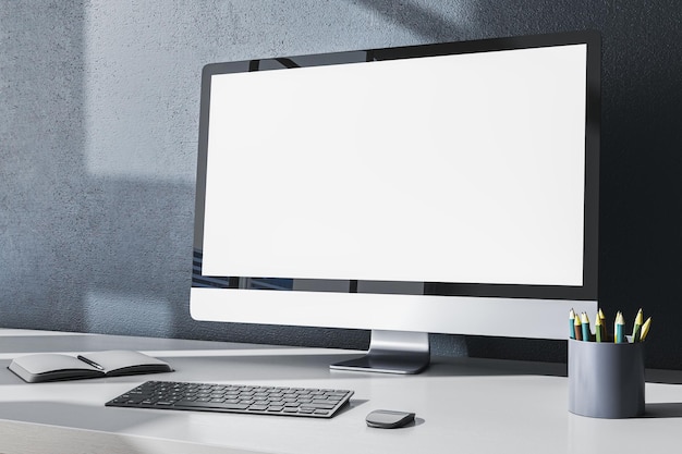 Escritorio de oficina de diseño contemporáneo con muestreo blanco vacío de suministros de monitor de computadora y otros artículos en fondo de pared gris Renderización 3D