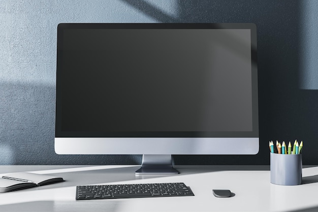 Escritorio de oficina de diseño moderno con muestreo vacío de suministros de monitor de computadora y otros artículos en fondo de pared gris Renderización 3D