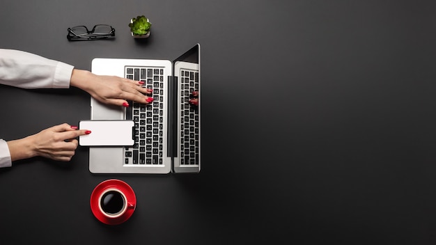 Escritorio de oficina con espacio de copia. Mujer que trabaja en la computadora portátil, panorama.