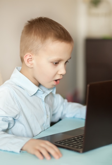 Escritorio de oficina con laptop. Niño aprendiendo en línea. Educación a distancia en línea.