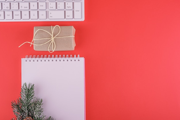 Escritorio de oficina de Navidad con teclado y bloc de notas en blanco