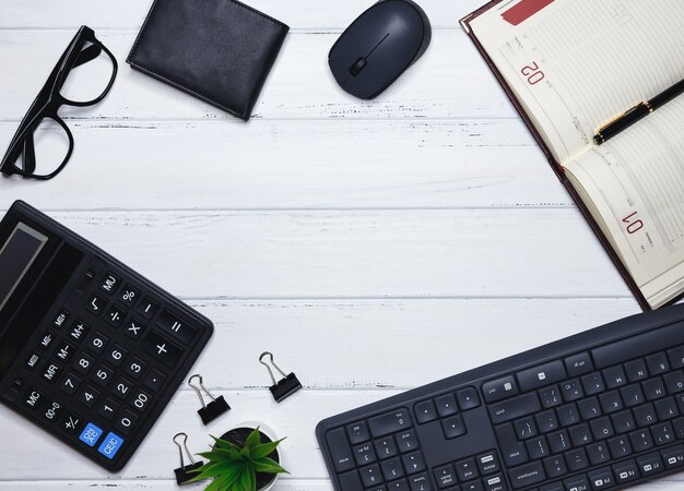 Escritorio de oficina con teclado, material de oficina, lápiz, hoja verde