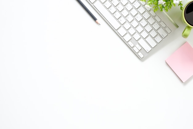 Escritorio de oficina de la vista superior con la computadora, el lápiz, la nota adhesiva, el papel del cuaderno y la taza de café.