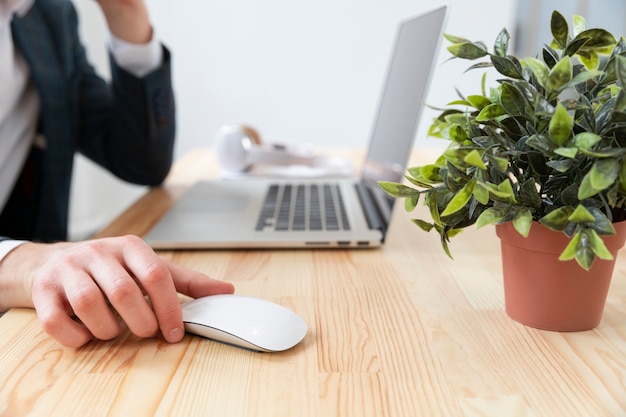 Escritorio de primer plano con tecnología y planta.