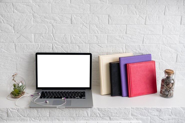 Foto escritorio de trabajo. computadora portátil abierta, libros y otros suministros de oficina.