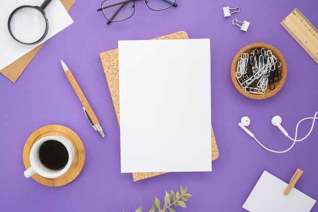 Escritorio de vista superior con material de oficina sobre fondo morado