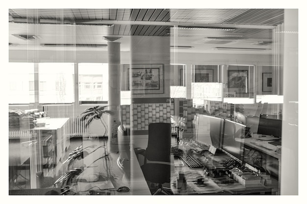 Foto escritório visto através de uma janela de vidro com reflexo