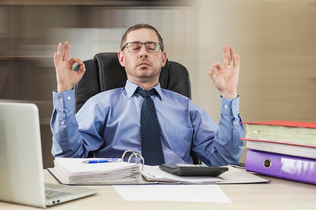 Escritório Zen empresário masculino relaxado meditando no local de trabalho lidando com o estresse no trabalho sentado na mesa com os olhos fechados