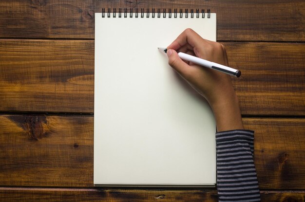 Foto escritura à mão recortada em um bloco de notas em uma mesa de madeira