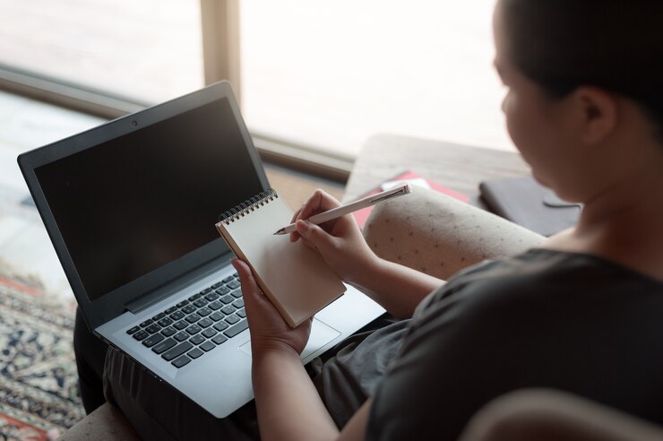 Foto escritura diestra de la mujer en la pequeña libreta