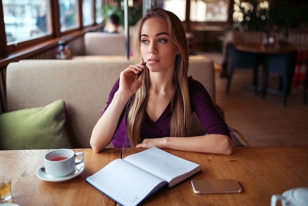 Escritura femenina en el cuaderno en el restaurante.