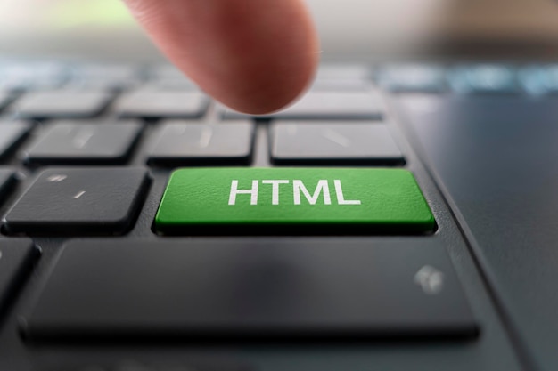 Escritura de lenguaje informático HTML en el botón moderno de la computadora portátil gris El dedo presiona el botón Programador para trabajar