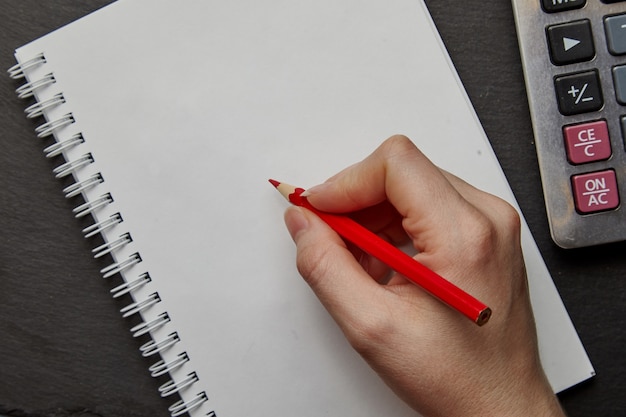 Foto escritura a mano en el cuaderno con lápiz rojo