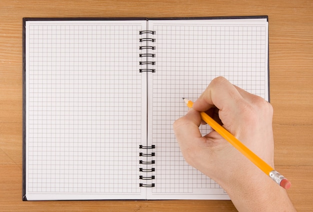 Escritura a mano con lápiz sobre cuaderno marcado