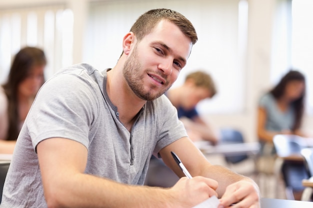 Escritura sonriente joven adulto