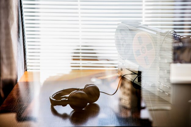 Escuchas telefónicas en la grabadora de carrete. Auriculares cerca de la técnica. Trabajo de agente especial. Retro vieja escuela espiando conversaciones.