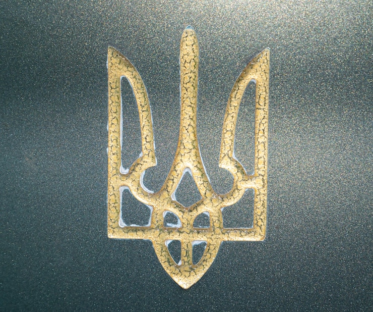 Foto escudo de armas dorado de ucrania trident sobre mármol verde