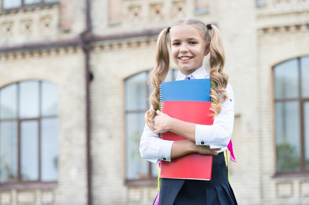 Una escuela de calidad. estudiar literatura para niños. aprender con la carpeta de documentos. día del conocimiento. educación escolar moderna. infancia feliz. chica adolescente con libro. niña bonita niño que va a leer.