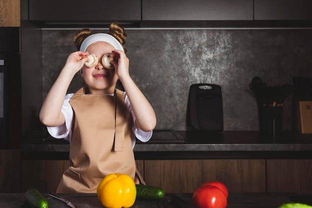 Foto escuela de cocina o culinaria para niños la niña cocina en la cocina preparando ingredientes disfrutando y divirtiéndose