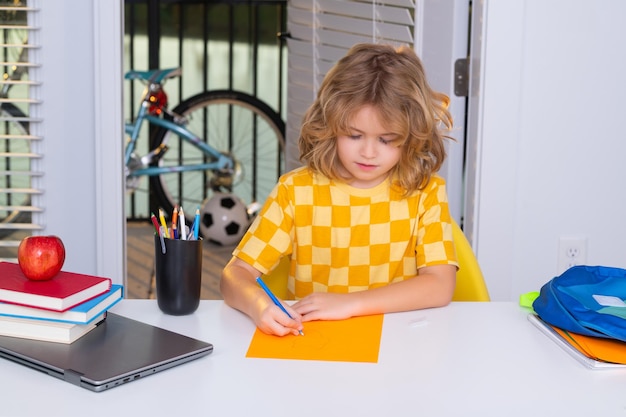 Escuela y concepto de educación retrato de niño lindo niño de la escuela sentado en la mesa escribiendo escuela h