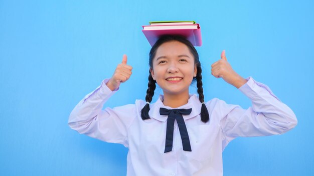 Escuela feliz con libro sobre fondo azul.