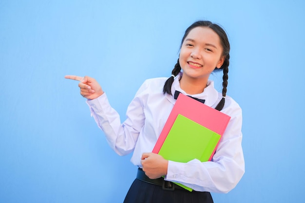 Escuela feliz con libro sobre fondo azul.