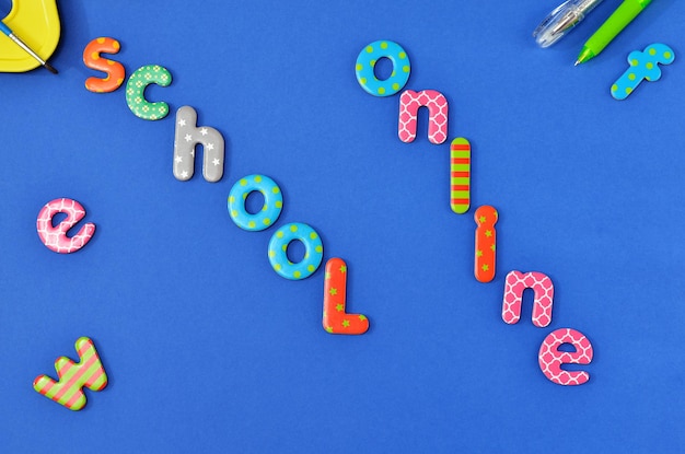 Foto la escuela de inscripción en línea a partir de las letras del alfabeto infantil sobre fondo azul