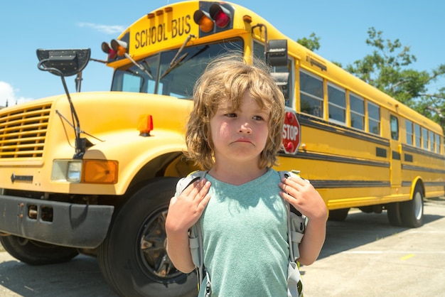 Foto escuela de niños tristes niño infeliz con mochila escolar primera vez en la escuela regreso a la escuela