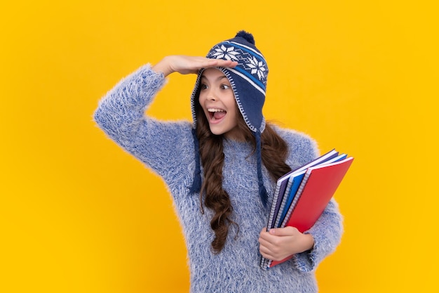 Escuela de otoño Colegiala adolescente con libros en ropa de otoño sobre fondo de estudio aislado amarillo Chica adolescente sorprendida