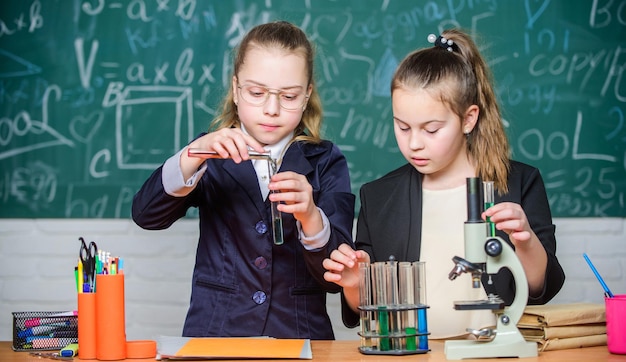 Escuela privada. Investigación del proyecto escolar. Experimento escolar. Concepto de ciencia. Alumnos de gimnasia con un profundo estudio de las ciencias naturales. Uniforme escolar de niñas ocupado probando su hipótesis.