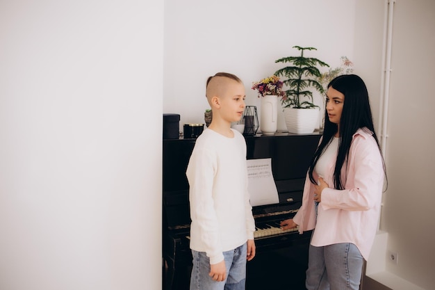 Foto escuela vocal una maestra dirige un canto con un niño