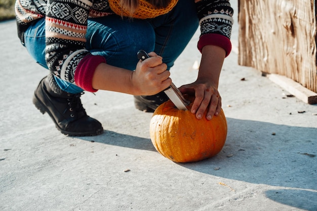 Esculpindo abóbora em lanterna jack para decoração de férias de halloween ao ar livre