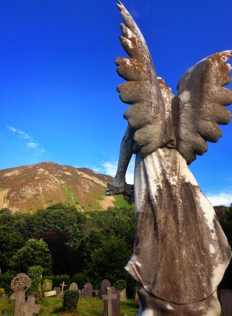 Escultura de un ángel frente al cementerio