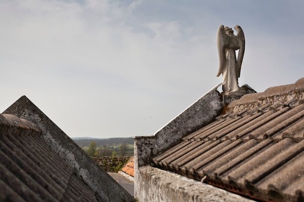 Escultura del ángel de la guarda en los techos de los panteones en un concepto religioso del cementerio