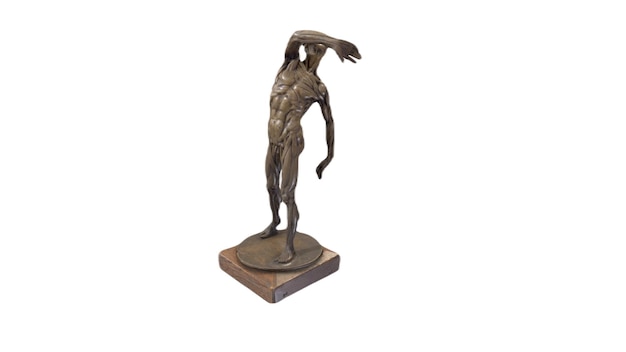 Una escultura de bronce de un hombre con los brazos extendidos y la cabeza levantada.