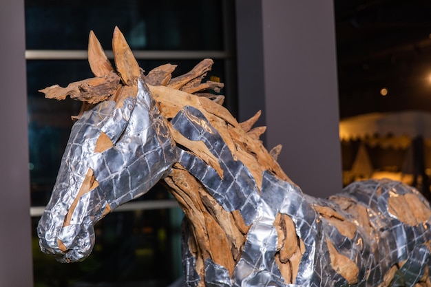 Una escultura de caballo plateado con hojas.