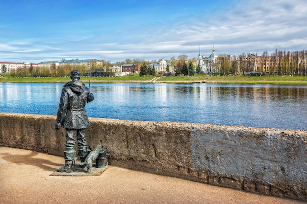 Escultura de um pescador no aterro do Volga no templo de Tver e Voskresensky à distância