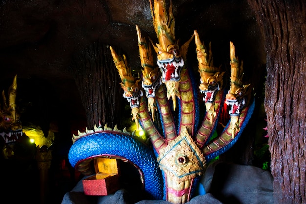 Escultura esculpindo naga antiga ou estátua de naka antiga para viajantes tailandeses que viajam, visitam e respeitam a oração, bênção, desejo, mito sagrado, mistério no templo wat don khanak em nakhon pathom, tailândia