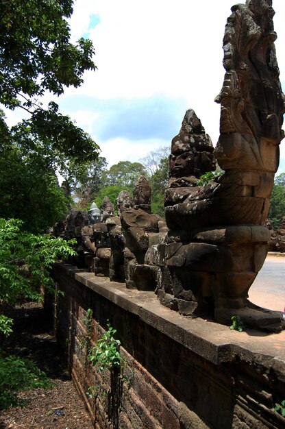 Escultura escultura figura divindade anjo espírito e estátua naga na entrada ruínas antigas construindo nokor thom da ponte south gate na cultura hindu e budista ir para angkor wat em siem reap camboja