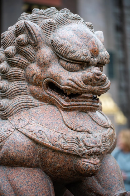 Escultura de un león al estilo oriental cerca de un templo budista datsan