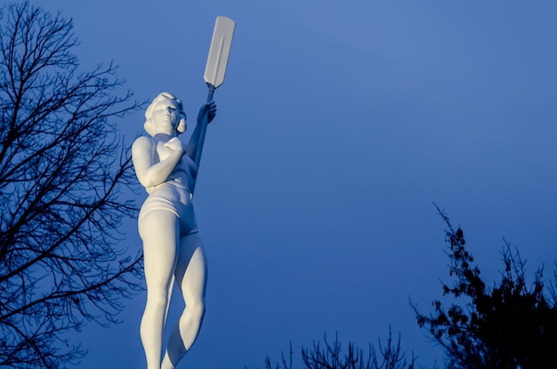 Escultura de una mujer con un remo en el parque.