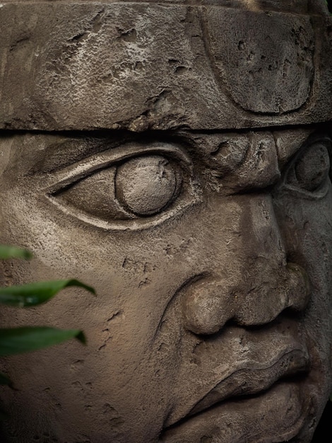 Foto escultura olmeca esculpida em pedra símbolo maia grande estátua de cabeça de pedra em uma selva