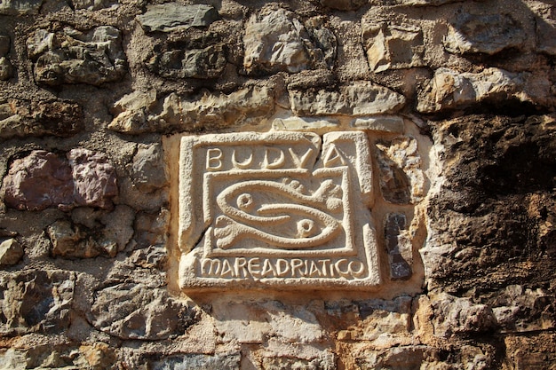 Escultura en la pared, dos peces, símbolo de la ciudad de Budva en Montenegro