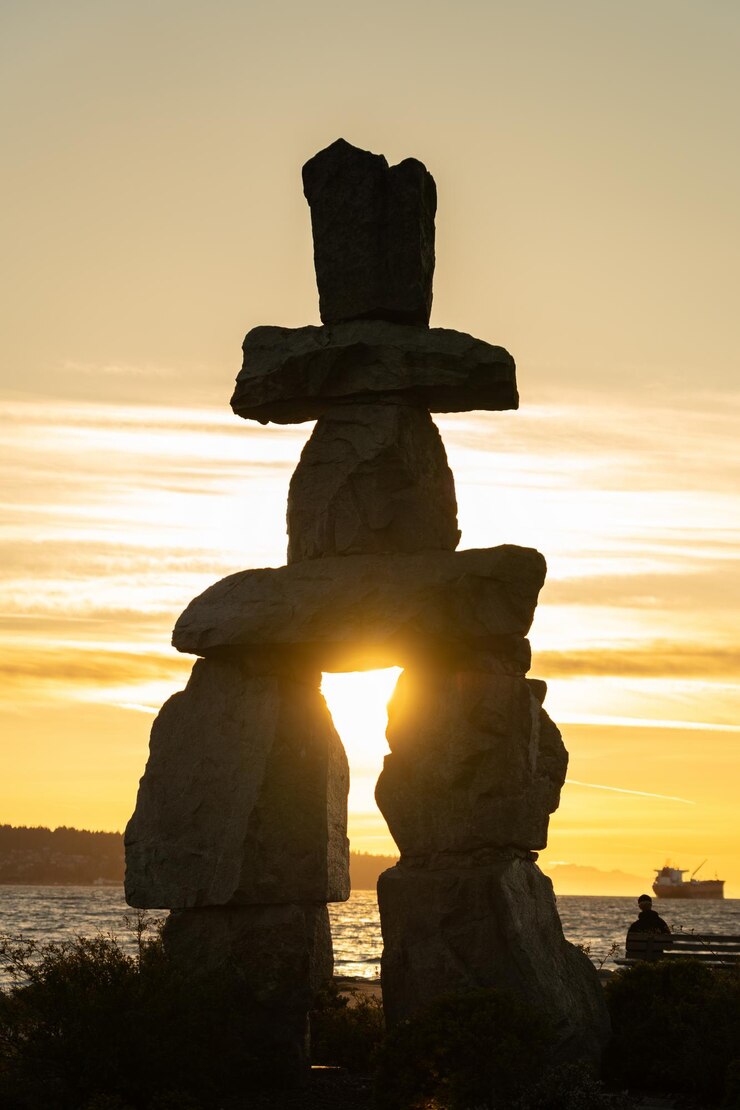 Escultura de piedra Inukshuk al atardecer en English Bay Beach Vancouver City hermoso paisaje