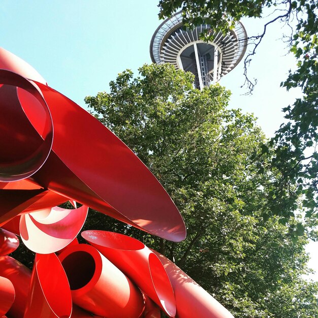 Escultura vermelha abstrata com agulha espacial no fundo