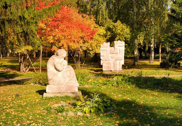 Esculturas de jardim no outono Park Esculturas de mármore cercadas por folhagem brilhante