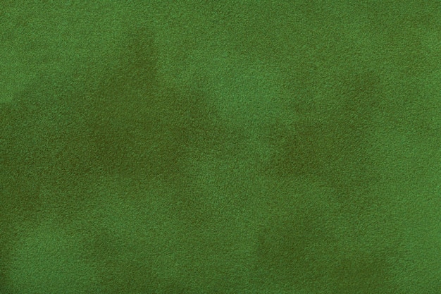 Escuro - fundo matte verde da tela da camurça, close up.