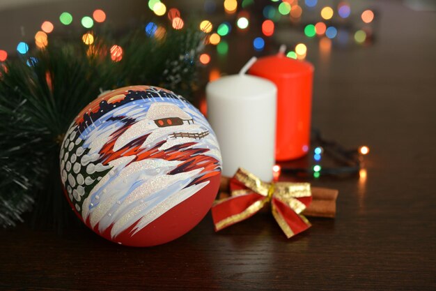 esfera de natal com laço vermelho, velas e luzes guirlanda